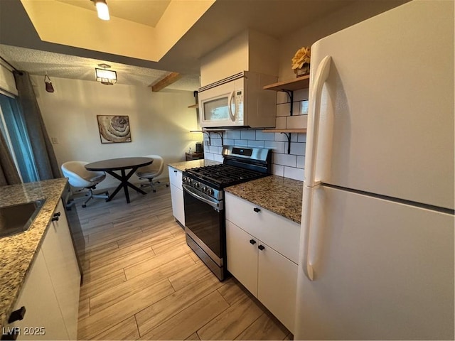 kitchen with open shelves, light wood-style floors, white appliances, white cabinetry, and decorative backsplash