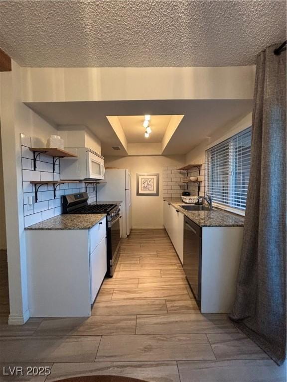 kitchen featuring range with gas stovetop, open shelves, black dishwasher, white microwave, and wood finish floors
