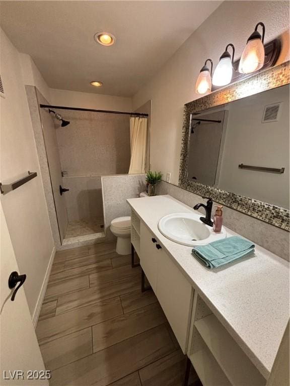 bathroom featuring visible vents, vanity, toilet, recessed lighting, and a shower stall