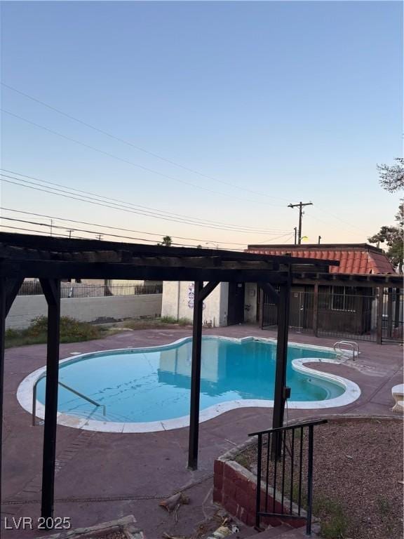 community pool with fence and a patio area
