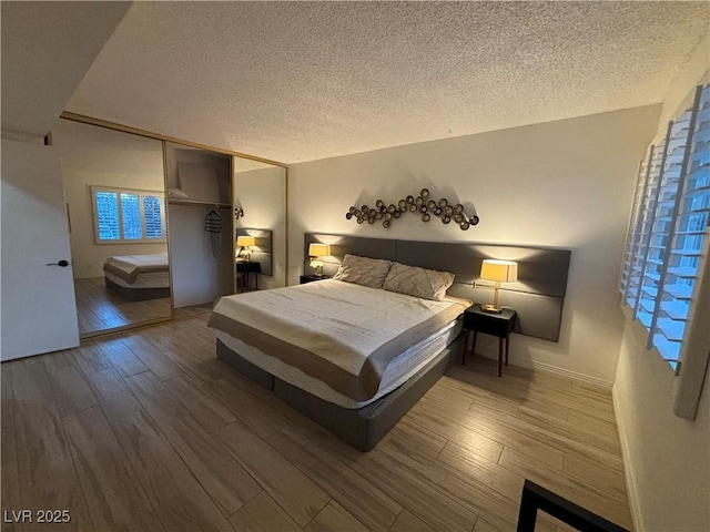 bedroom with a textured ceiling and wood finished floors