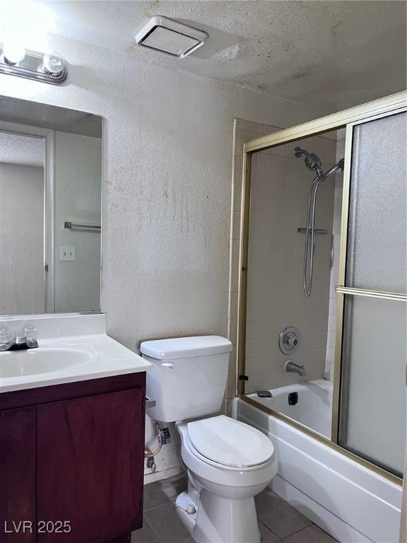 805 Rock Springs Dr Unit 101, Las Vegas, NV 89128 - full bathroom featuring toilet, tile patterned flooring, vanity, and combined bath / shower with glass door