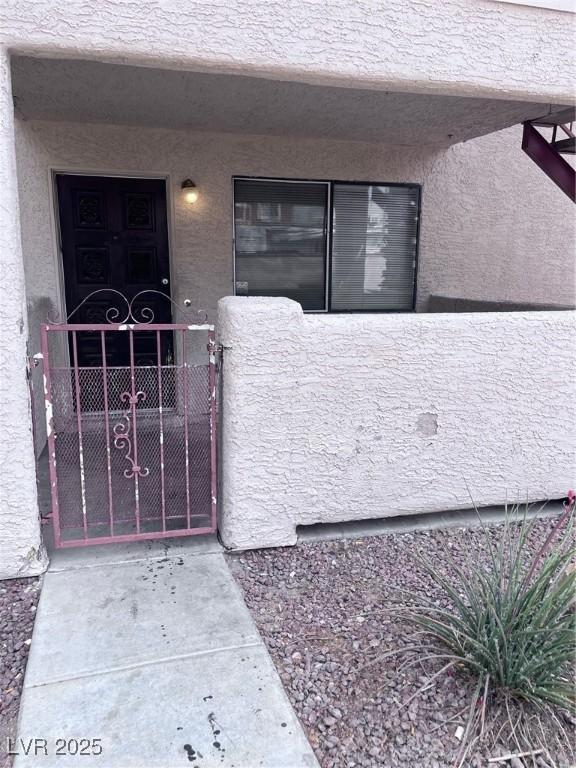805 Rock Springs Dr Unit 101, Las Vegas, NV 89128 - property entrance featuring stucco siding, fence, and a gate