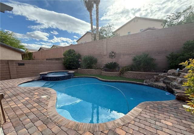 view of swimming pool featuring a fenced backyard, a pool with connected hot tub, and a patio area