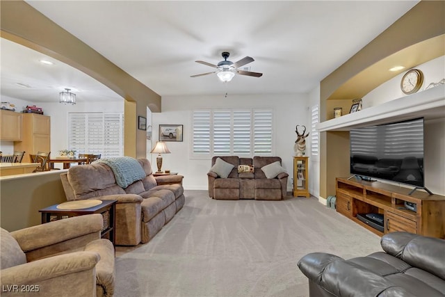 7013 Bisoni St, Las Vegas, NV 89149 - living area featuring ceiling fan, baseboards, light colored carpet, and arched walkways