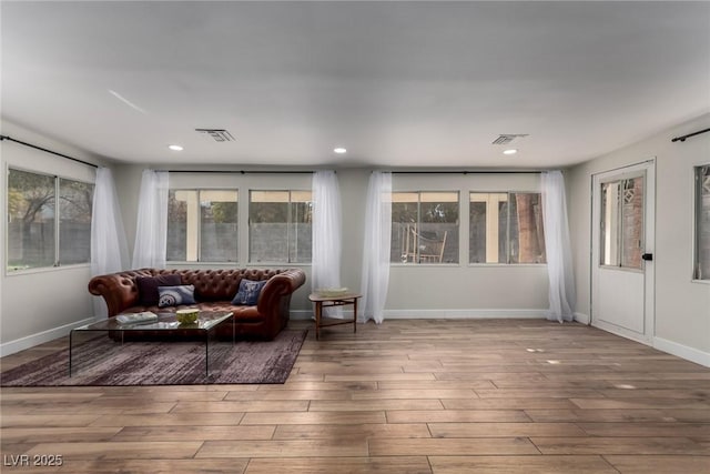 interior space featuring baseboards, recessed lighting, wood finished floors, and visible vents