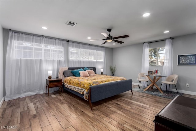 bedroom with ceiling fan, recessed lighting, baseboards, wood finished floors, and visible vents