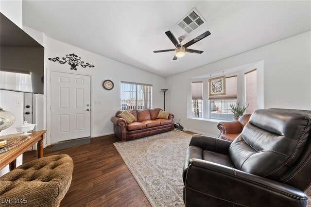 living area with visible vents, baseboards, ceiling fan, dark wood-style floors, and vaulted ceiling