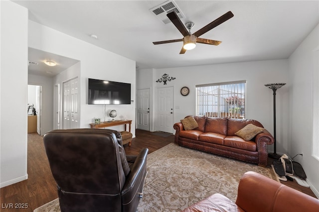 living room featuring visible vents, baseboards, ceiling fan, and wood finished floors