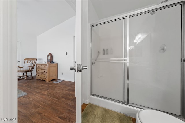 full bathroom featuring a shower stall, toilet, and wood finished floors