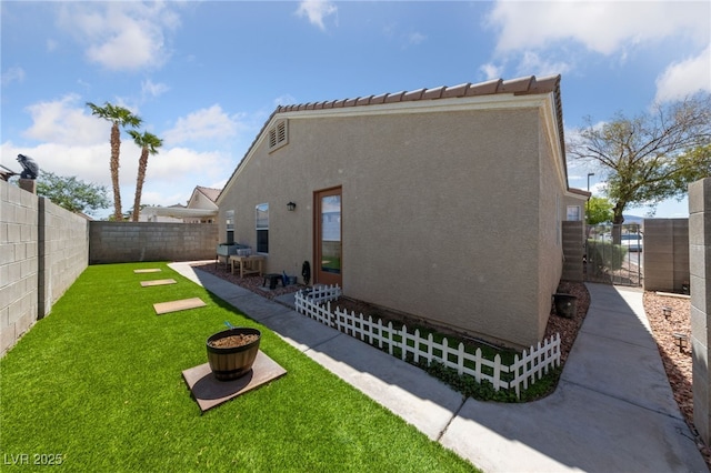 back of property featuring a fenced backyard, stucco siding, a yard, and a patio area