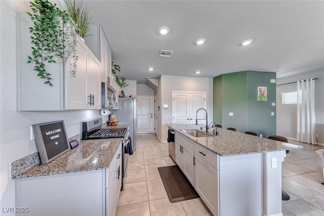 kitchen featuring a sink, appliances with stainless steel finishes, white cabinetry, and visible vents