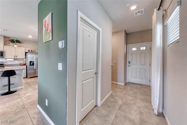 hall featuring visible vents, recessed lighting, baseboards, and light tile patterned floors