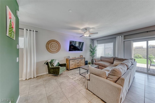 living room with baseboards, ceiling fan, and light tile patterned flooring
