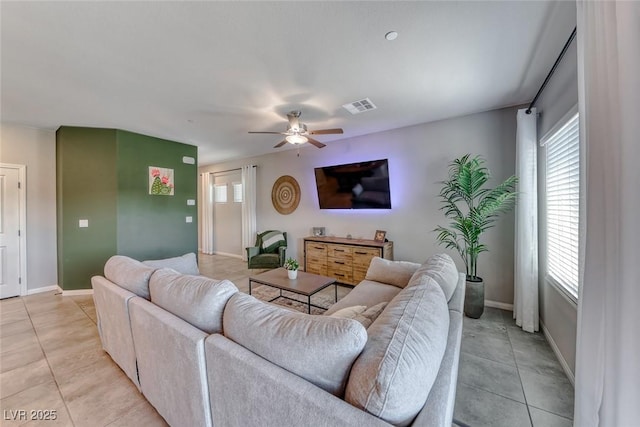living area with visible vents, a ceiling fan, baseboards, and light tile patterned floors