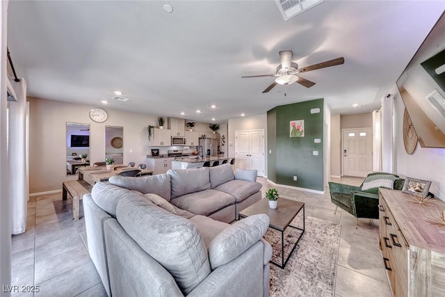 living room with ceiling fan, visible vents, light tile patterned floors, baseboards, and recessed lighting