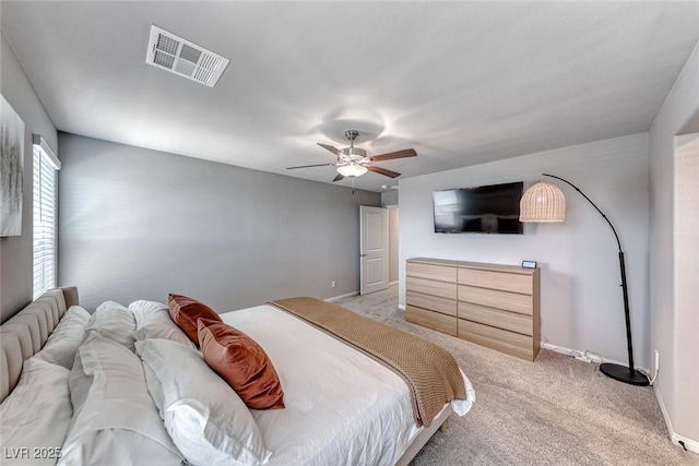 bedroom with visible vents, a ceiling fan, baseboards, and light colored carpet