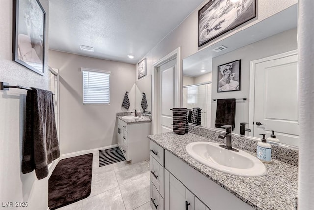 full bath featuring visible vents, two vanities, a sink, and a stall shower