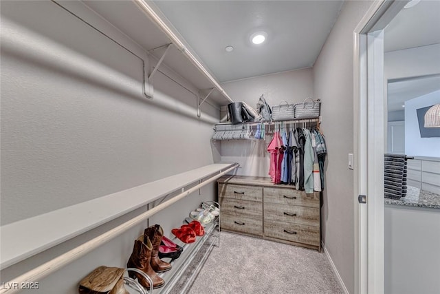 walk in closet featuring light colored carpet