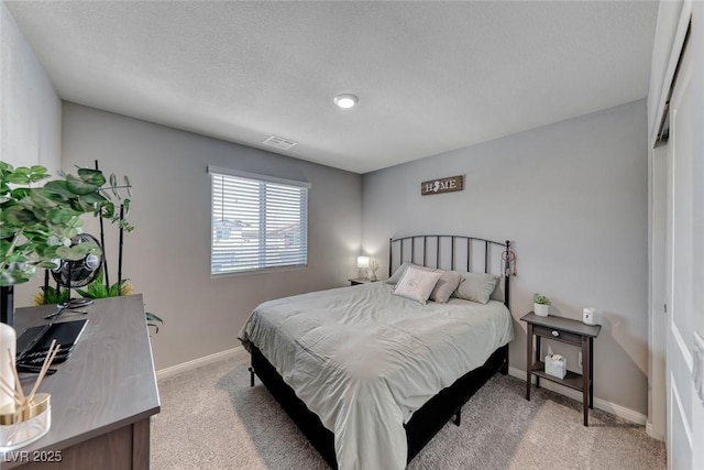 bedroom with visible vents, a textured ceiling, baseboards, and light colored carpet