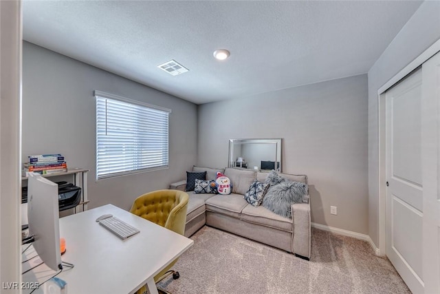 office featuring carpet flooring, a textured ceiling, baseboards, and visible vents