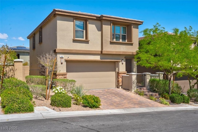 traditional home featuring decorative driveway, a garage, and stucco siding