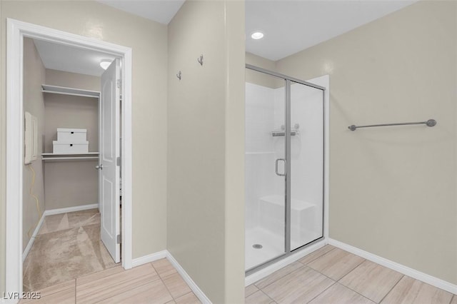 full bath with baseboards and a shower stall