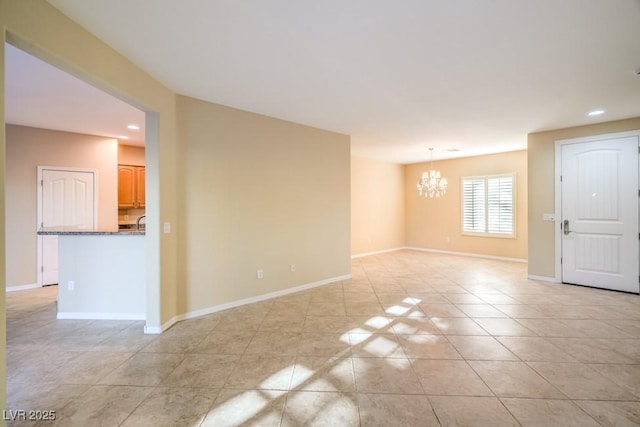 spare room featuring recessed lighting, baseboards, light tile patterned floors, and a chandelier