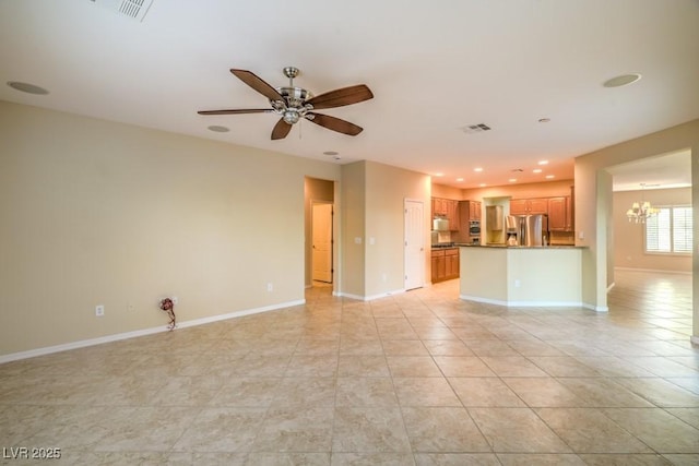 unfurnished living room with visible vents, baseboards, ceiling fan with notable chandelier, and light tile patterned floors