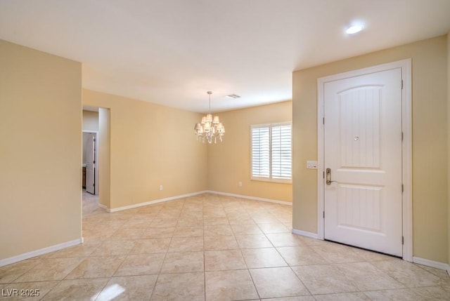 unfurnished room with baseboards, a notable chandelier, and light tile patterned floors