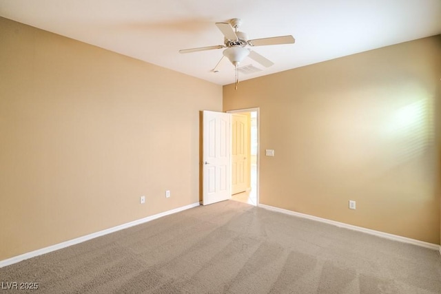 carpeted spare room featuring baseboards, ceiling fan, and visible vents