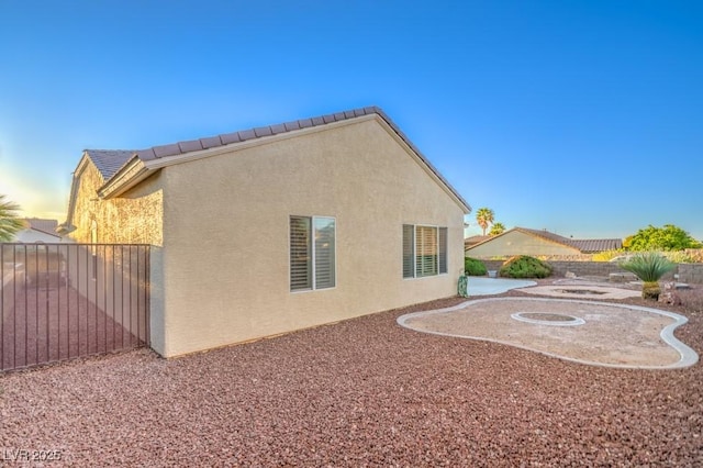 view of home's exterior with fence and stucco siding