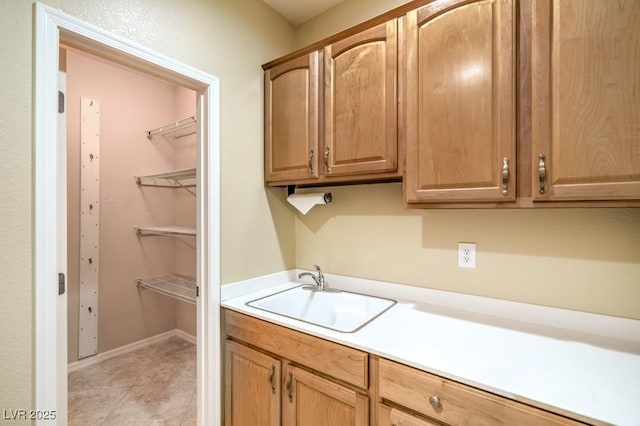 laundry room with light tile patterned floors and a sink