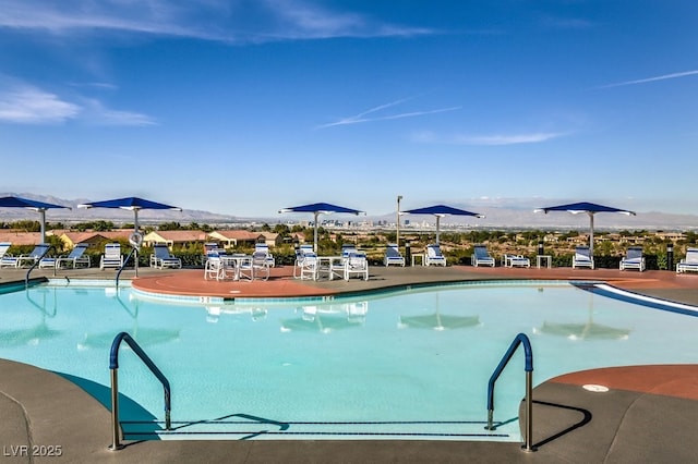 community pool featuring a mountain view and a patio