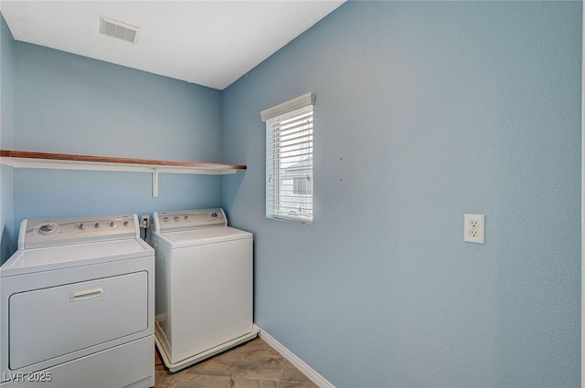 washroom with baseboards, visible vents, laundry area, and washer and clothes dryer
