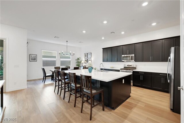 712 Webber Park St, Henderson, NV 89011 - kitchen with recessed lighting, appliances with stainless steel finishes, a kitchen island with sink, and light wood-type flooring