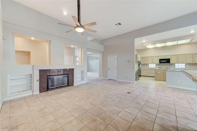 8052 Marbella Cir, Las Vegas, NV 89128 - unfurnished living room featuring a high end fireplace, a ceiling fan, light tile patterned floors, built in features, and high vaulted ceiling
