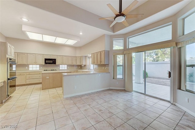 8052 Marbella Cir, Las Vegas, NV 89128 - kitchen featuring black microwave, double oven, light countertops, a ceiling fan, and light tile patterned floors