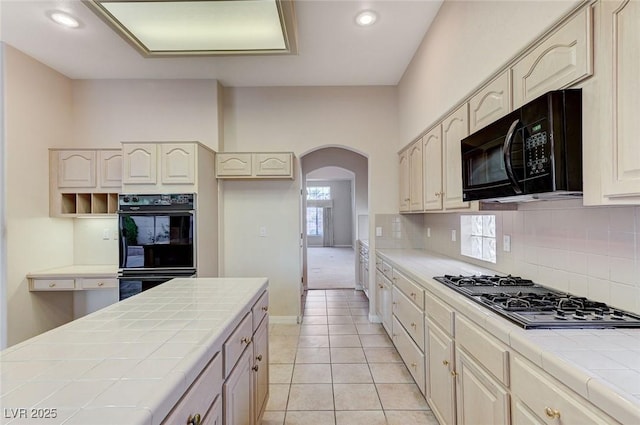 8052 Marbella Cir, Las Vegas, NV 89128 - kitchen featuring black appliances, tile countertops, arched walkways, backsplash, and recessed lighting