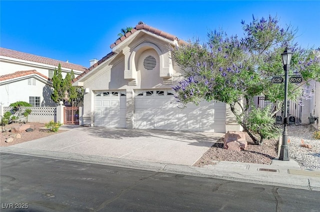 8052 Marbella Cir, Las Vegas, NV 89128 - view of front facade with a tiled roof, concrete driveway, stucco siding, and a gate