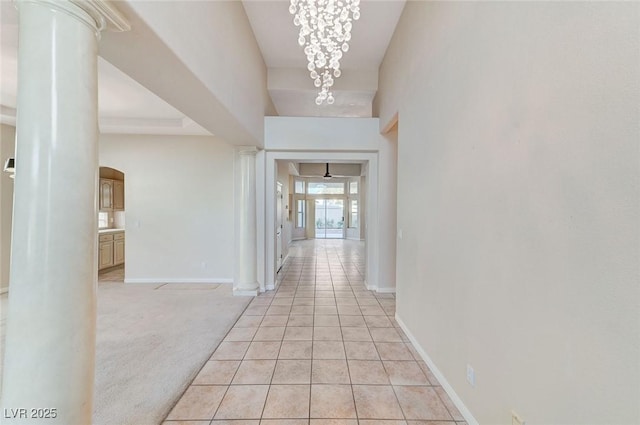 8052 Marbella Cir, Las Vegas, NV 89128 - corridor with arched walkways, ornate columns, baseboards, light tile patterned flooring, and a chandelier