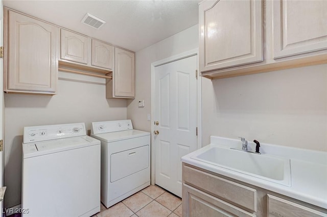 8052 Marbella Cir, Las Vegas, NV 89128 - laundry area featuring washing machine and clothes dryer, cabinet space, and light tile patterned floors