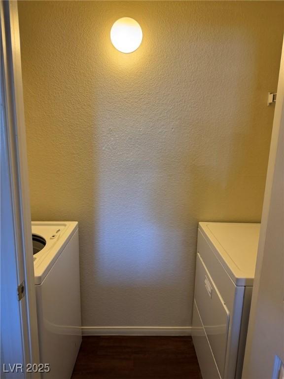 laundry room with baseboards, laundry area, dark wood finished floors, and washer and clothes dryer