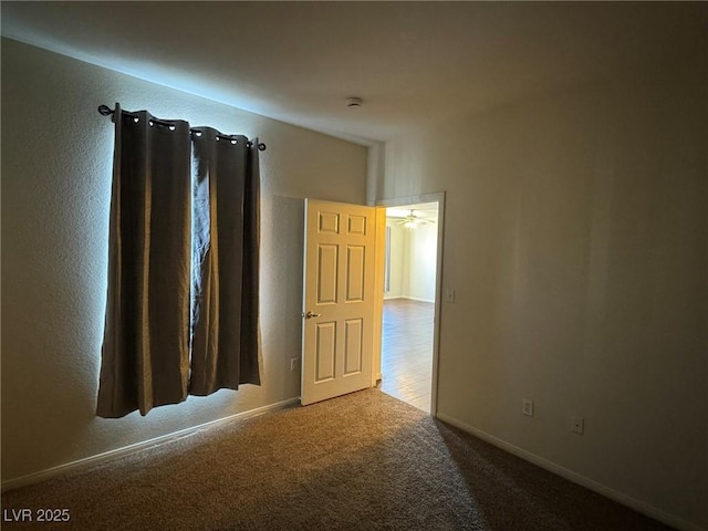 empty room with baseboards and carpet flooring