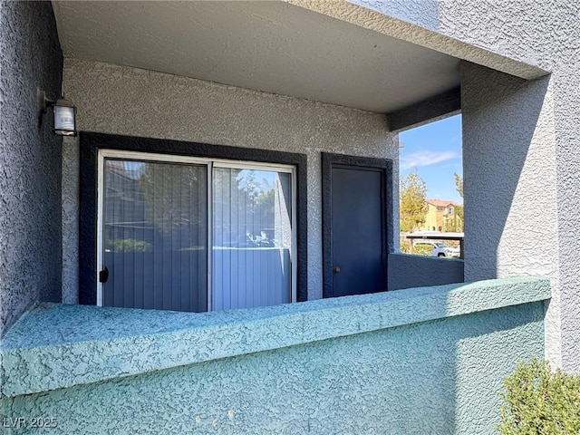 exterior space with a balcony and stucco siding