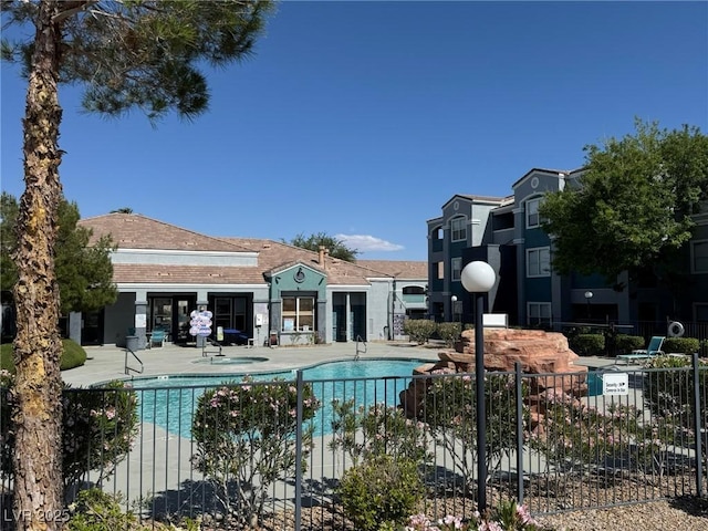 community pool featuring fence and a patio