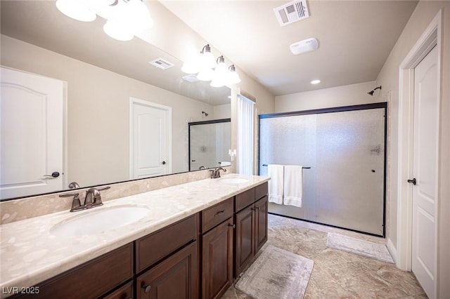 bathroom with visible vents, a shower stall, and a sink