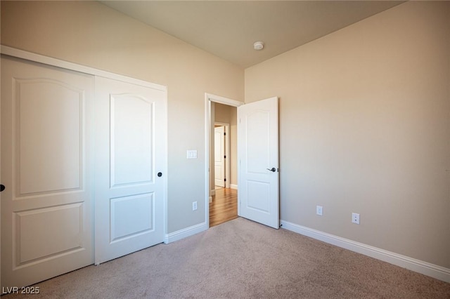 unfurnished bedroom featuring carpet floors, baseboards, and a closet