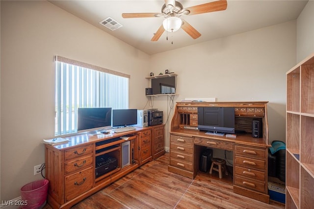 office space with ceiling fan, light wood-type flooring, and visible vents