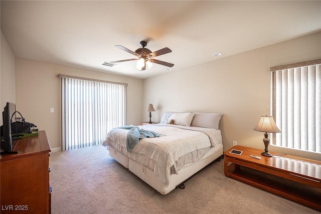 bedroom with visible vents, a ceiling fan, baseboards, and light carpet